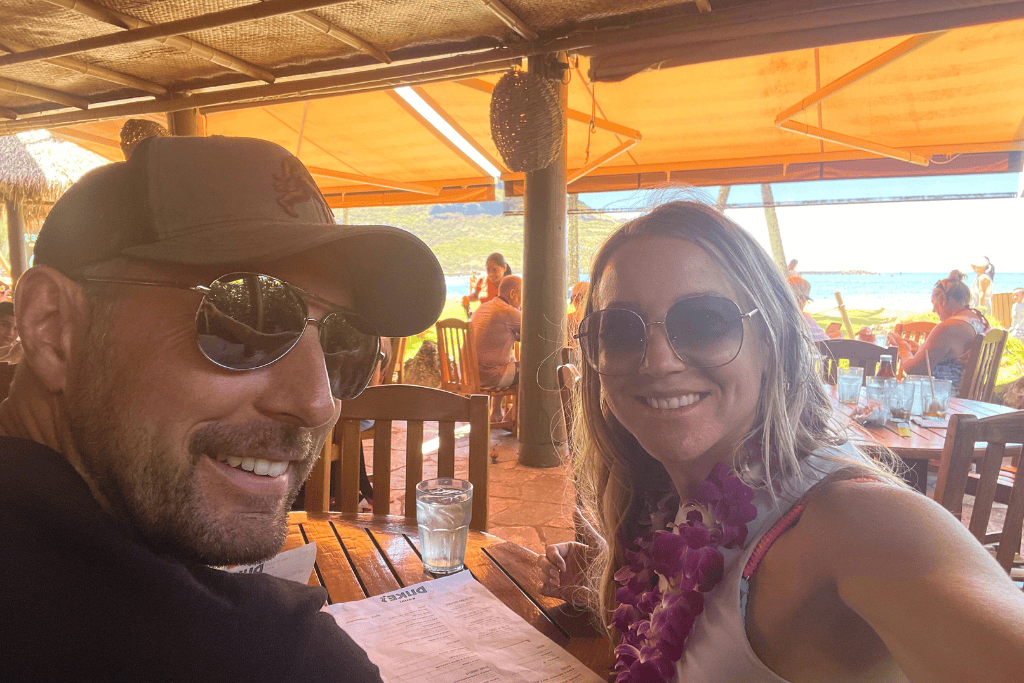 Kate and her companion smile over a beachside meal at Duke’s Kauai.
