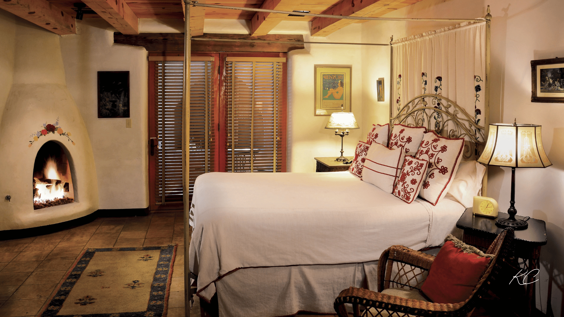 A cozy and inviting hotel room in Sedona featuring a comfortable bed with decorative pillows, a warm fireplace, and rustic wooden accents.