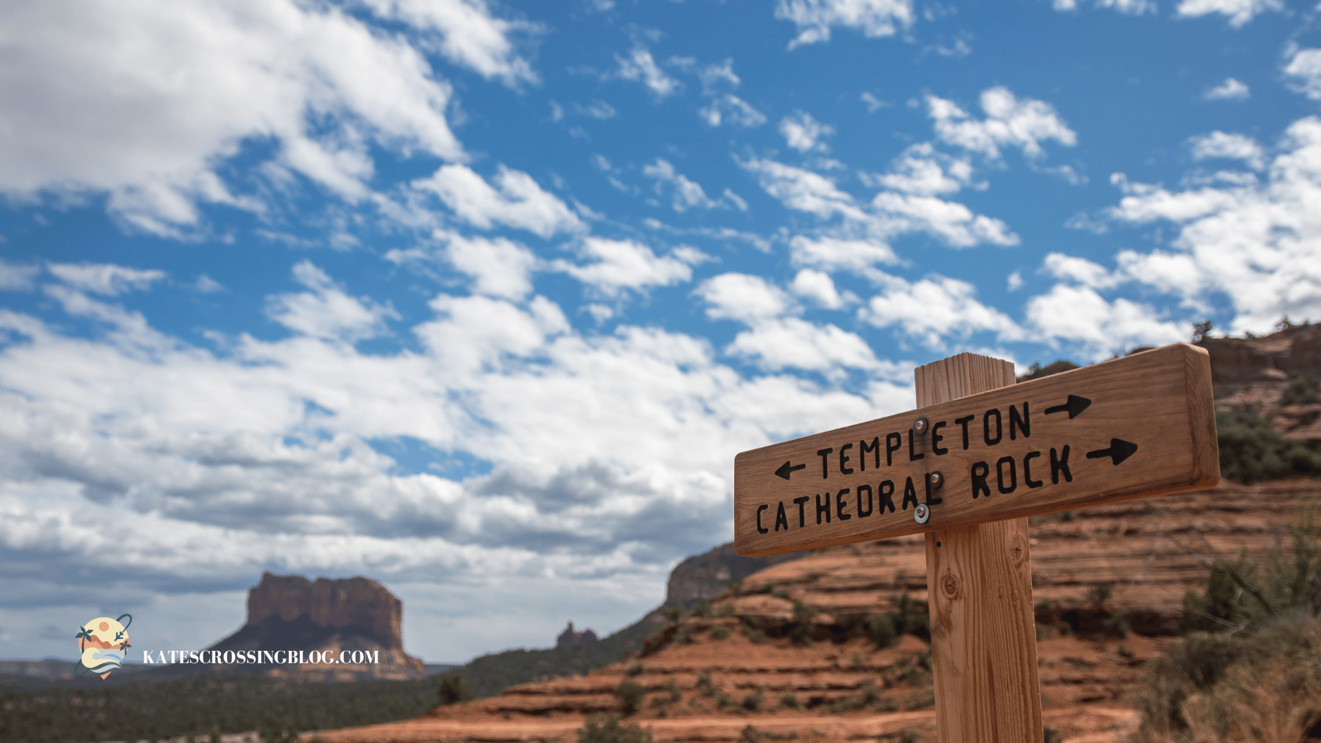 A wooden signpost indicating directions to Templeton and Cathedral Rock trails, set against a backdrop of Sedona's red rock formations and a bright, partly cloudy sky.