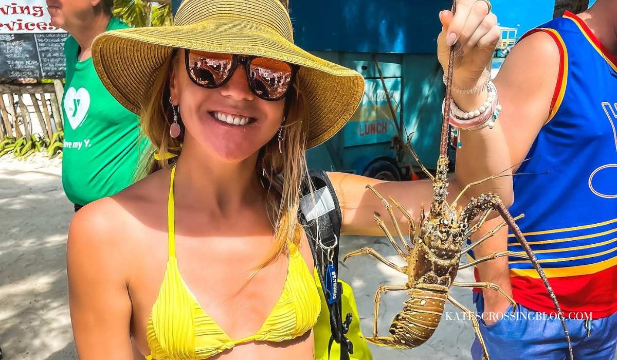 Lobster season on Caye caulker. I'm holding a rock lobster by its tentacle. Its a sunny hot day and i'm in my yellow bathing suit during January.