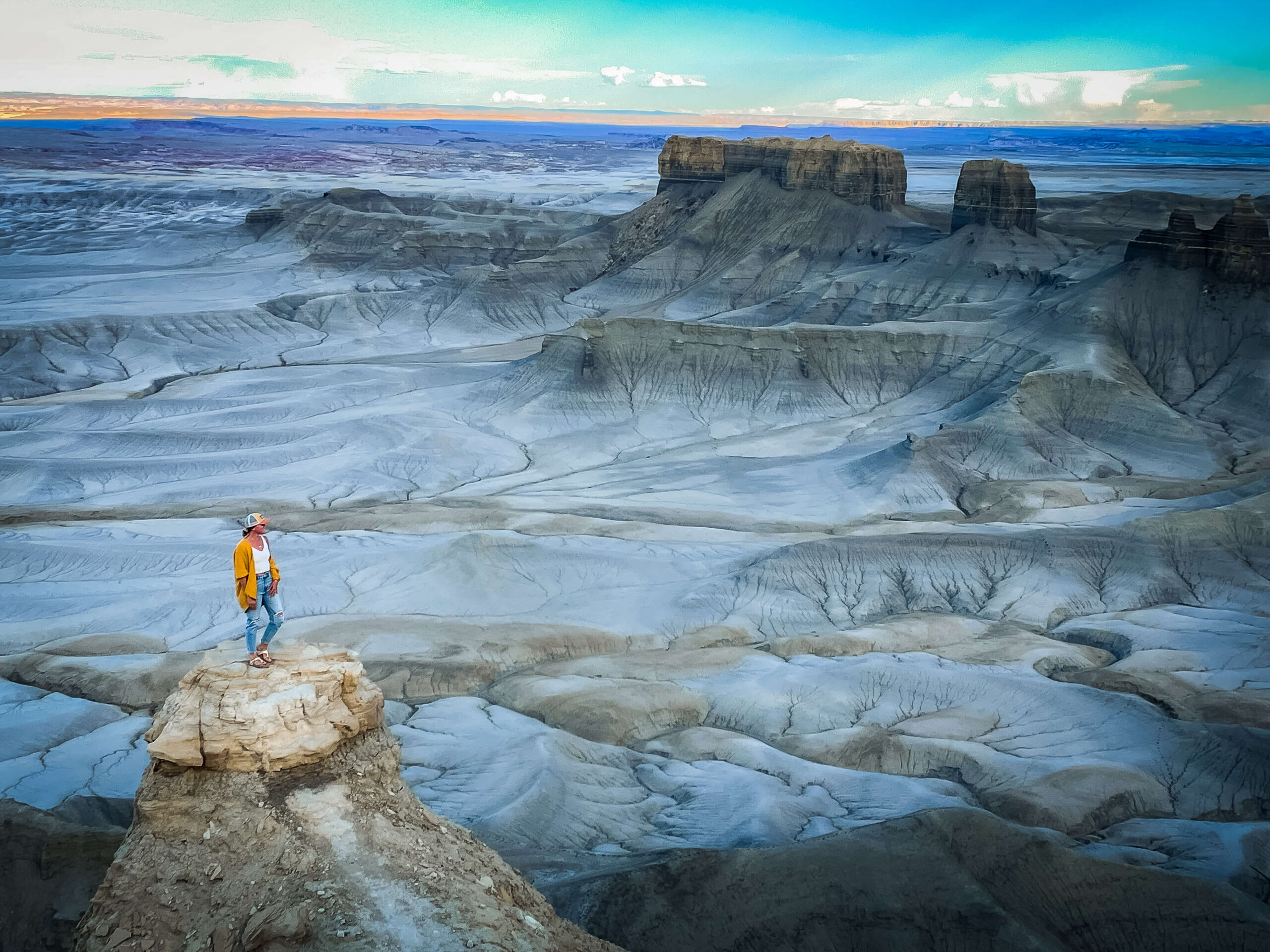 Kate from Kate's Crossing Blog standing at Moonscape Overlook in Utah, gazing at the surreal, otherworldly landscape.