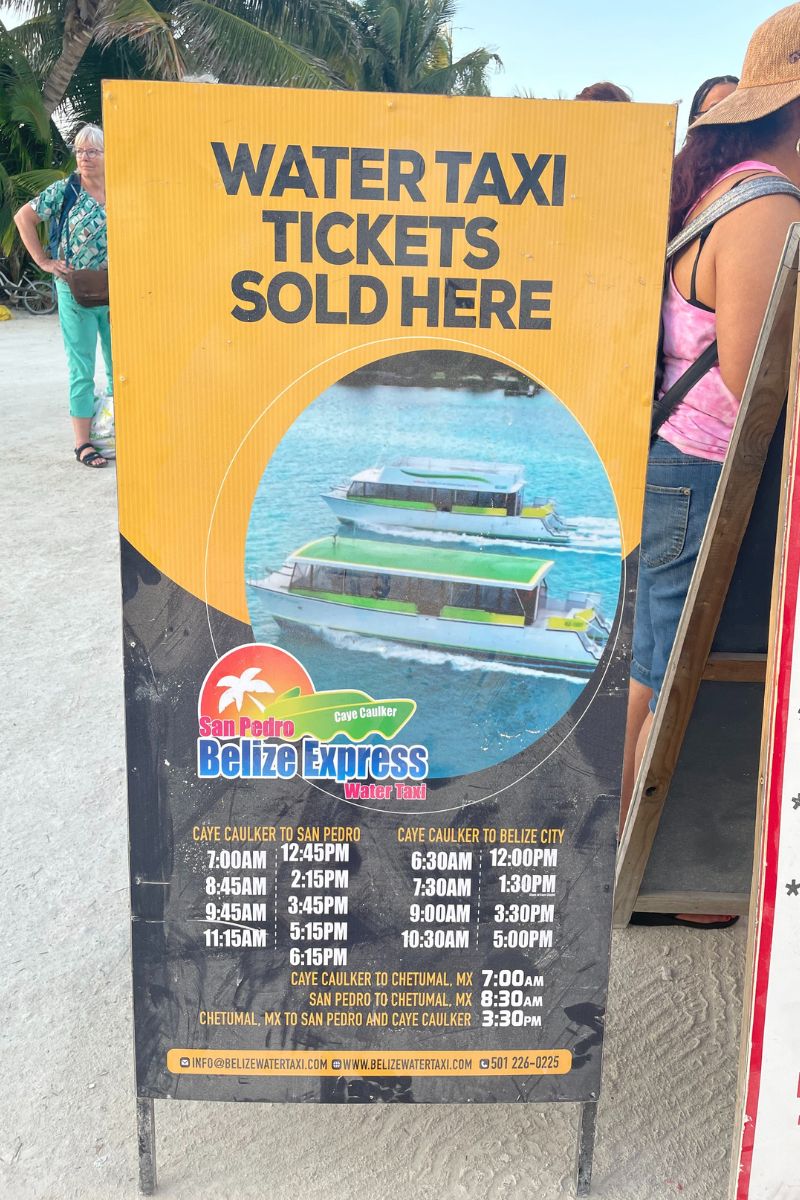 Sign for San Pedro Belize Express water taxi tickets with schedule times for departures from Caye Caulker to San Pedro, Belize City, and Chetumal, Mexico.