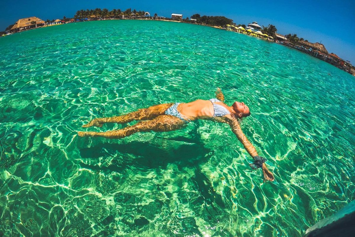 Kate floating in the clear turquoise waters of Belize, enjoying the sunshine. This photo captures the best time to visit Belize for a relaxing and sunny getaway.