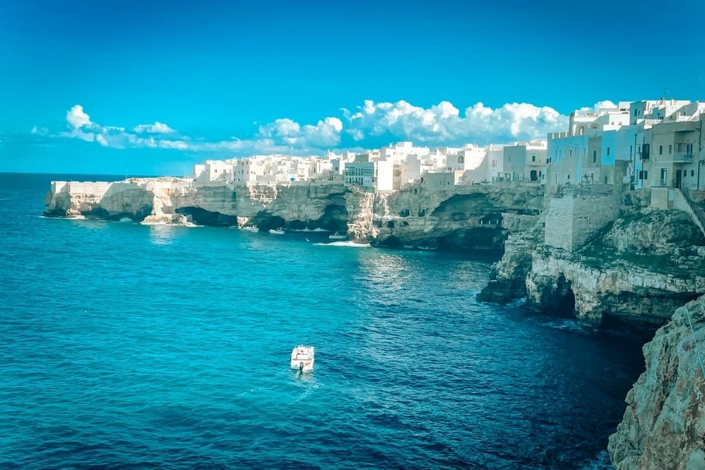 Stunning coastal cliffs of Polignano a Mare in Puglia, Italy, with whitewashed buildings perched above turquoise waters, perfectly capturing the allure of dream travel destinations.