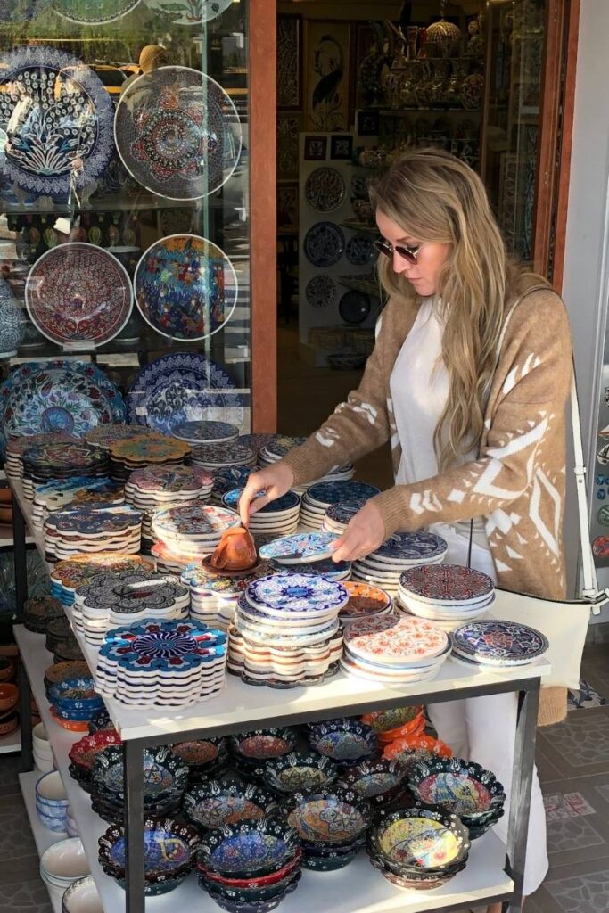 Kate browses a colorful display of hand-painted Turkish ceramics outside a pottery shop in Cappadocia.