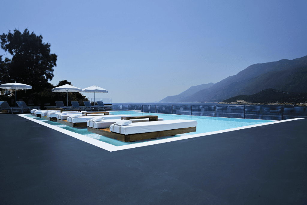 Sleek hotel infinity pool in Kaş with in-water loungers and panoramic views of the mountains and sea.