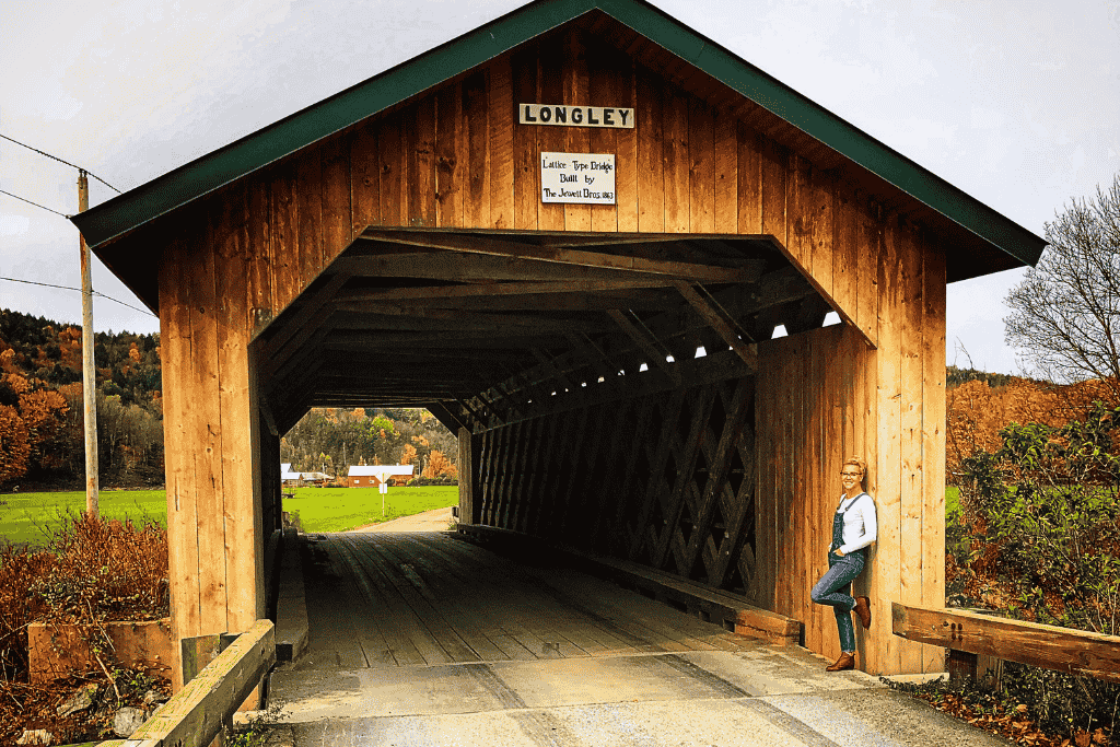 Kate standing by the Longley Covered Bridge in Montgomery, Vermont, during peak fall foliage season.