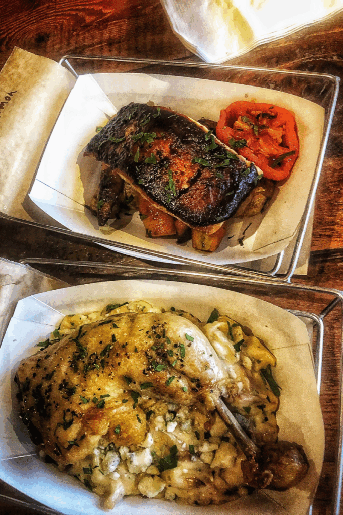 A farm-to-table meal at Worthy Kitchen features roasted chicken over gnocchi and a plate of grilled salmon with vegetables.