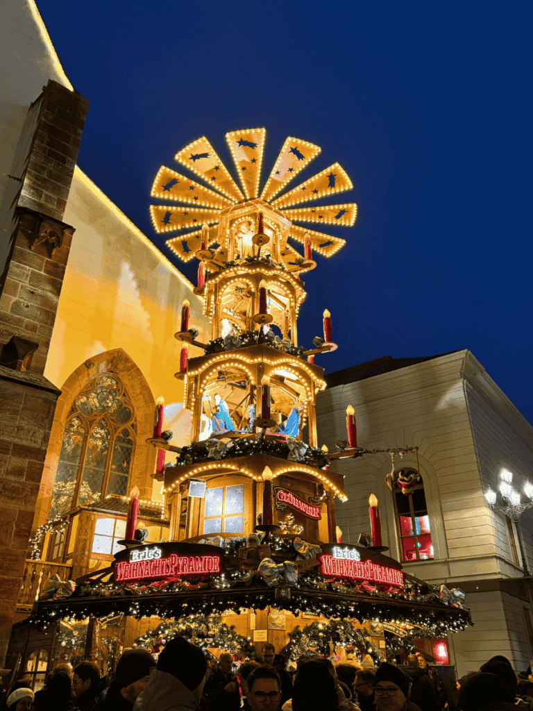 A brightly lit Christmas pyramid stall draws crowds at Basel’s festive market.