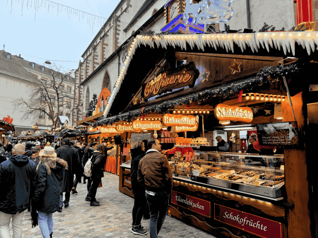 Crowds browse festive stalls selling sweets and treats at Basel’s Christmas market.