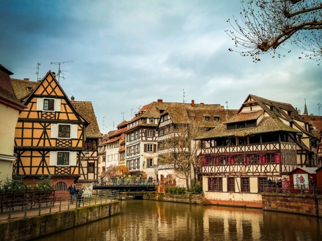 Charming half-timbered houses line the peaceful canal in Strasbourg’s Petite France district on a cloudy winter day.