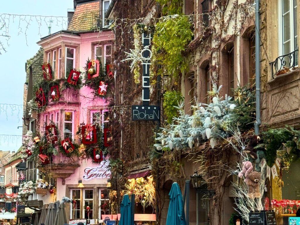 The exterior of Hotel Rohan and nearby shops in Strasbourg are decked out with pine branches, advent calendar numbers, and festive Christmas decor.