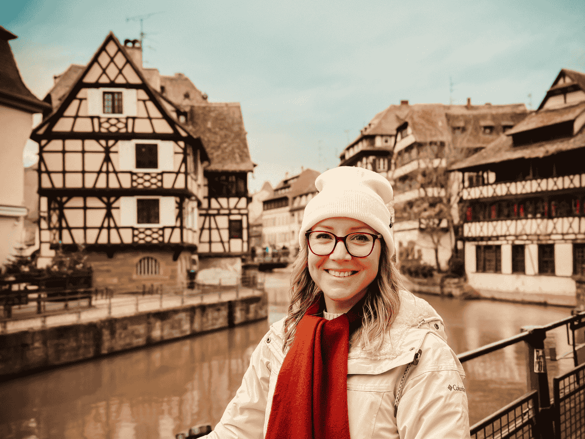 Kate stands smiling next to the canals in Petite Venice in Strasbourg, France.