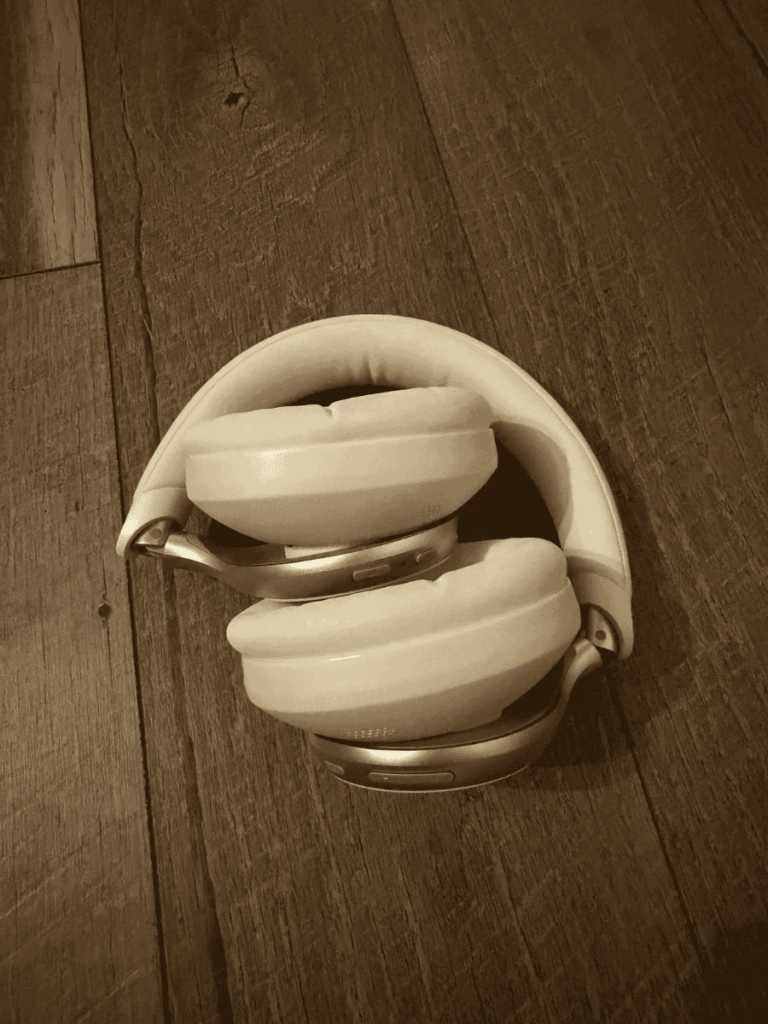 The same Soundcore headphones folded compactly for travel or storage, placed on a wooden floor.