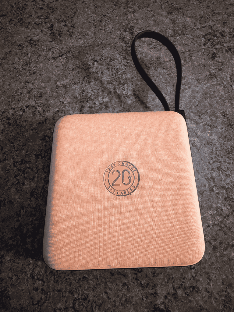 Compact pink portable power bank case with a black carrying strap, embossed with "20W Fast Charge 3-in-1 Cables" on the cover.
