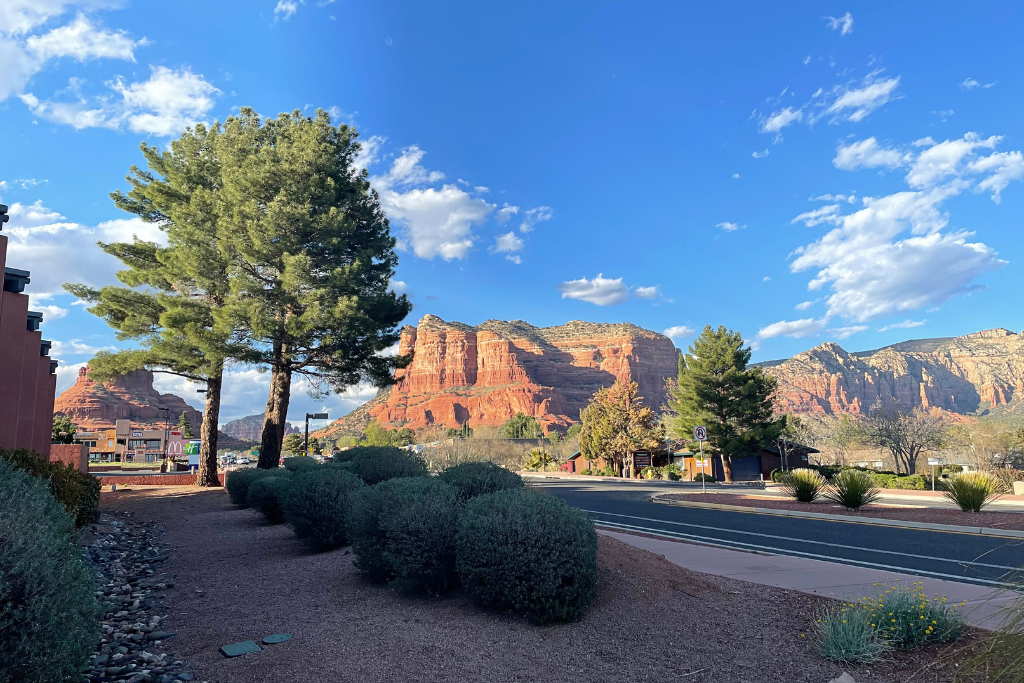 A street view of Sedona with red rocks towering over the town. 