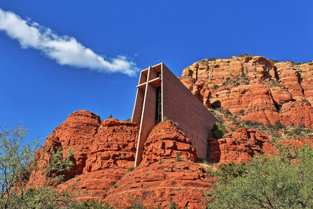 View looking up at the holy cross church in Sedona with a blue sky over head.