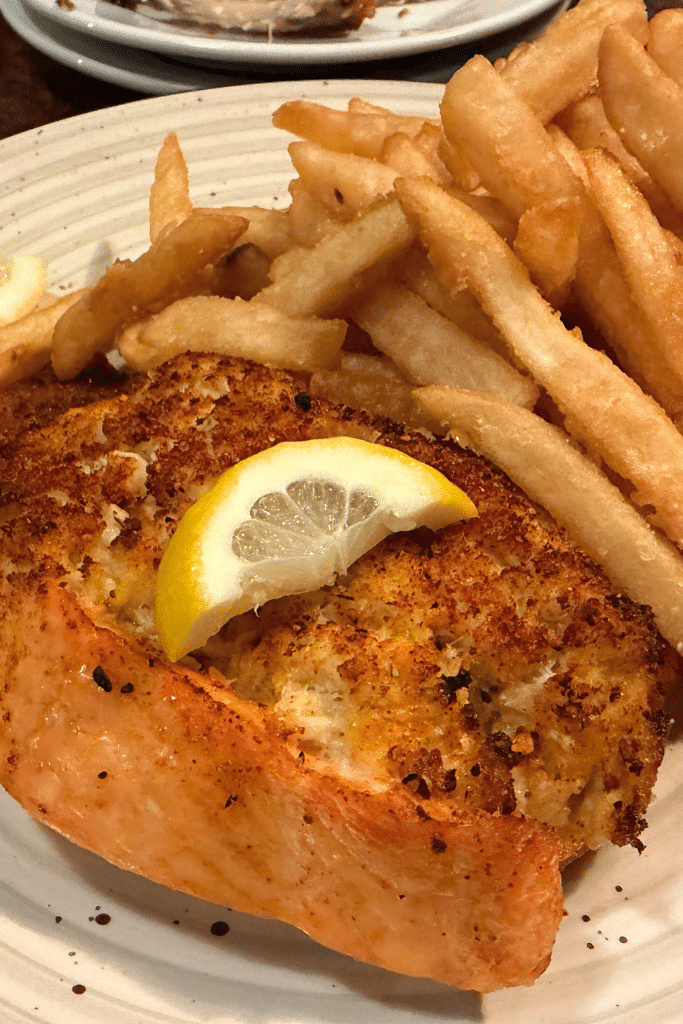 Plate of crispy breaded fish topped with a lemon wedge served with golden french fries during a casual meal out in Washington DC.