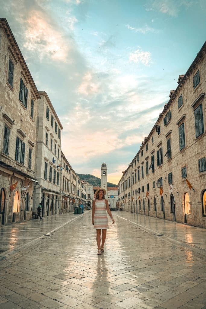 Kate walking down the the polished cobble stone street in Dubrovnik at sunrise.