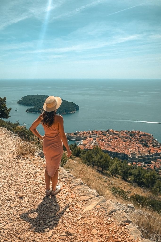 Kate standing at the top of Mount Srd overlooking the walled city of Dubrovnik and the sparkling coast below.