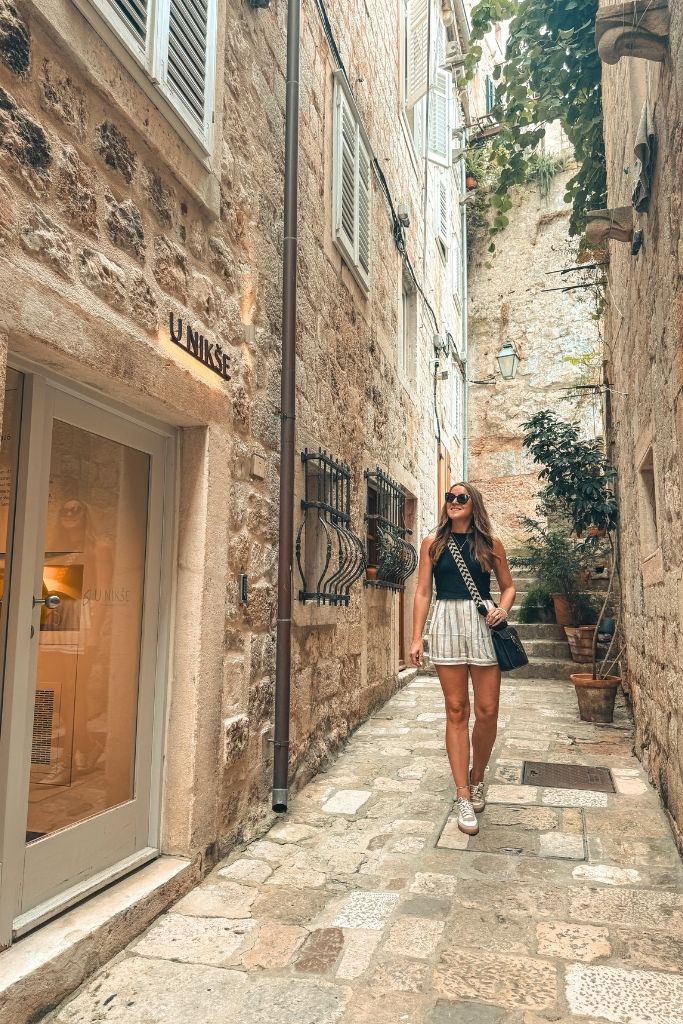 Kate walking down the narrow stone road to the front entrance of Apartments u Nikse.