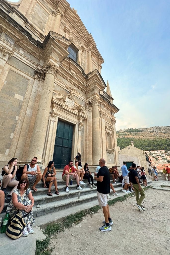 A guide talking to a group of tourists on a walking tour in Dubrovnik.