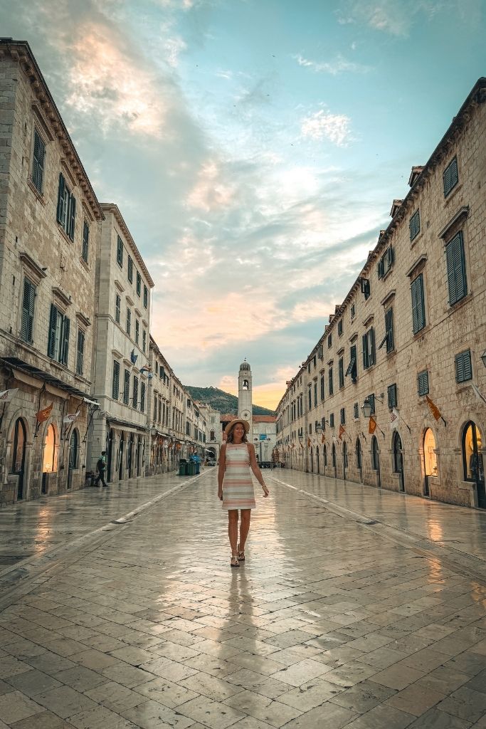 Kate is walking Stradun Street at sunrise with no one on the street. 