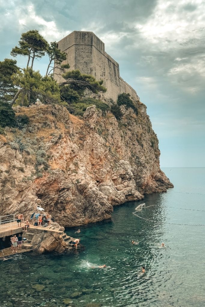 Lovrijenac Fortress high up on top the cliff looking over the small public beach.