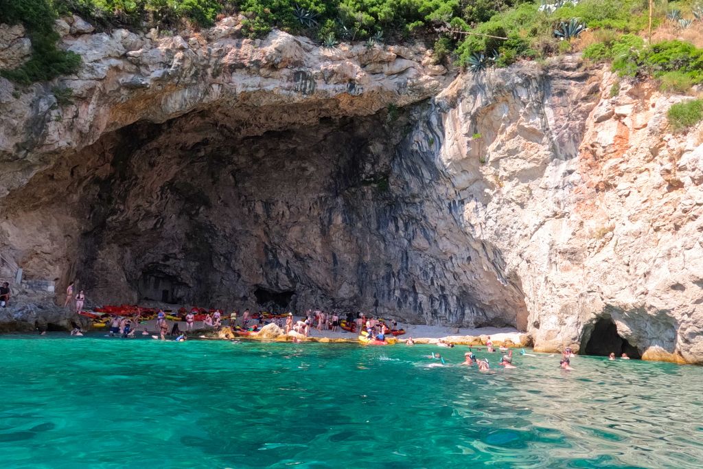 A cave with a sandy cove and turquoise waters surrounding it, off the coast of Dubrovnik.