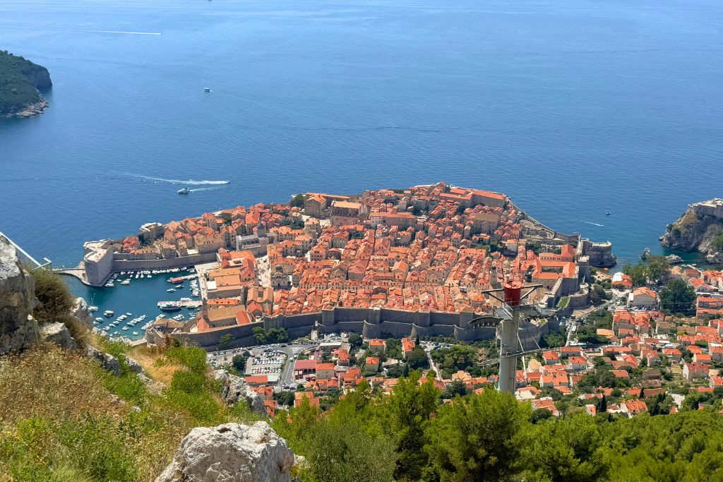 View of the walled city of Dubrovnik with its orange roofed buildings and the Adriatic sea from Mount Srd. 