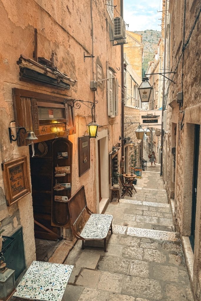 A view looking down the steps that lead down an old narrow stone street in Dubrovnik.