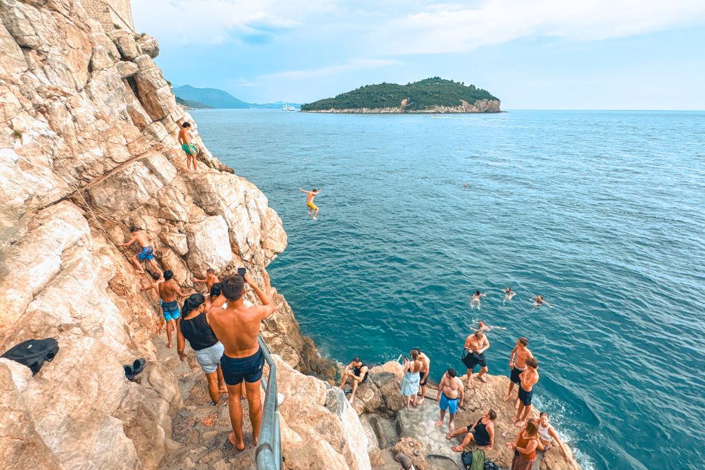 Swimmers cliff jumping into the Adriatic Sea from the Cliffs outside Dubrovnik. 