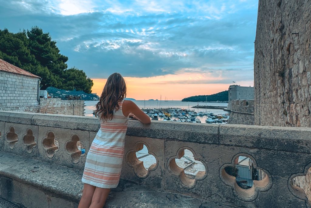 Kate is looking out at a sunrise over the port of Dubrovnik.