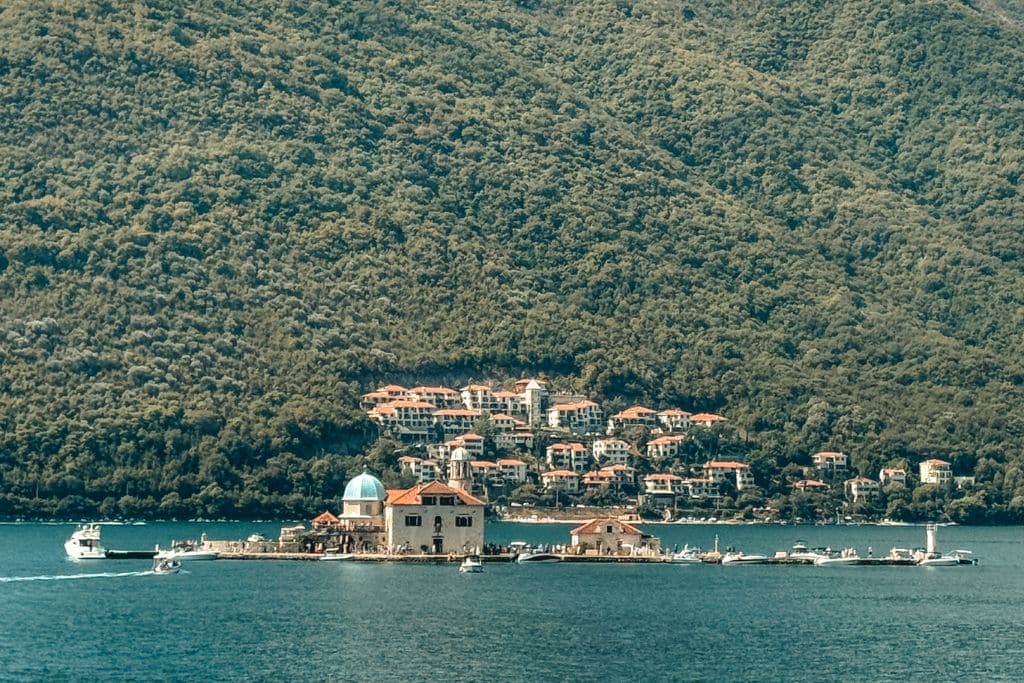 Our Lady of the Rocks, the famous man-made island church in the Bay of Kotor, sits surrounded by Montenegro’s stunning mountain scenery and crystal-clear water.