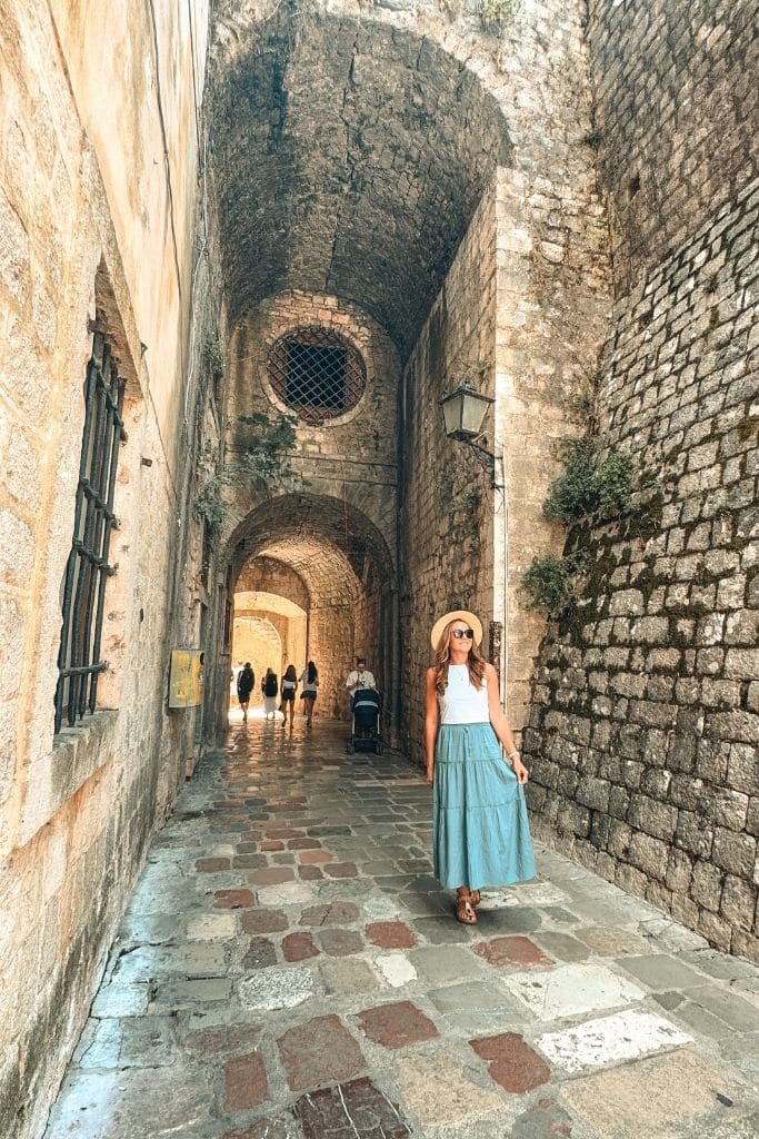 Kate wanders through one of Kotor Old Town’s atmospheric stone alleyways, surrounded by centuries-old architecture and charming medieval details.