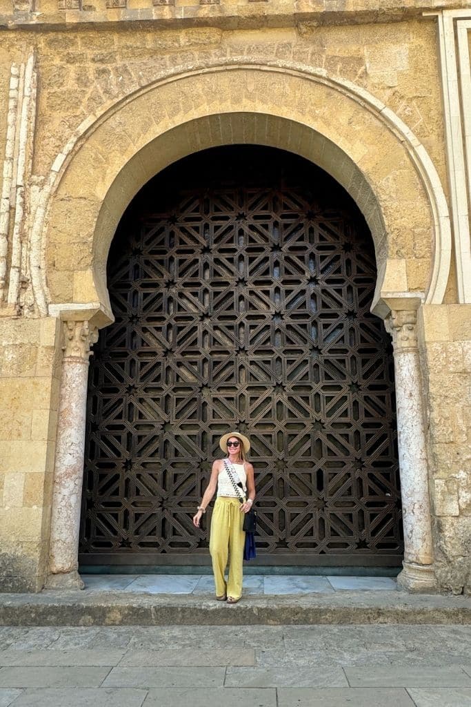 Kate explores Europe in summer wearing breezy linen pants, comfortable sandals, and a wide brim hat — an effortless outfit for staying cool while sightseeing in the heat.