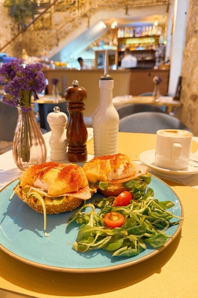 Eggs Benedict with a garden salad on a plate in Lvxor Cafe in Split.