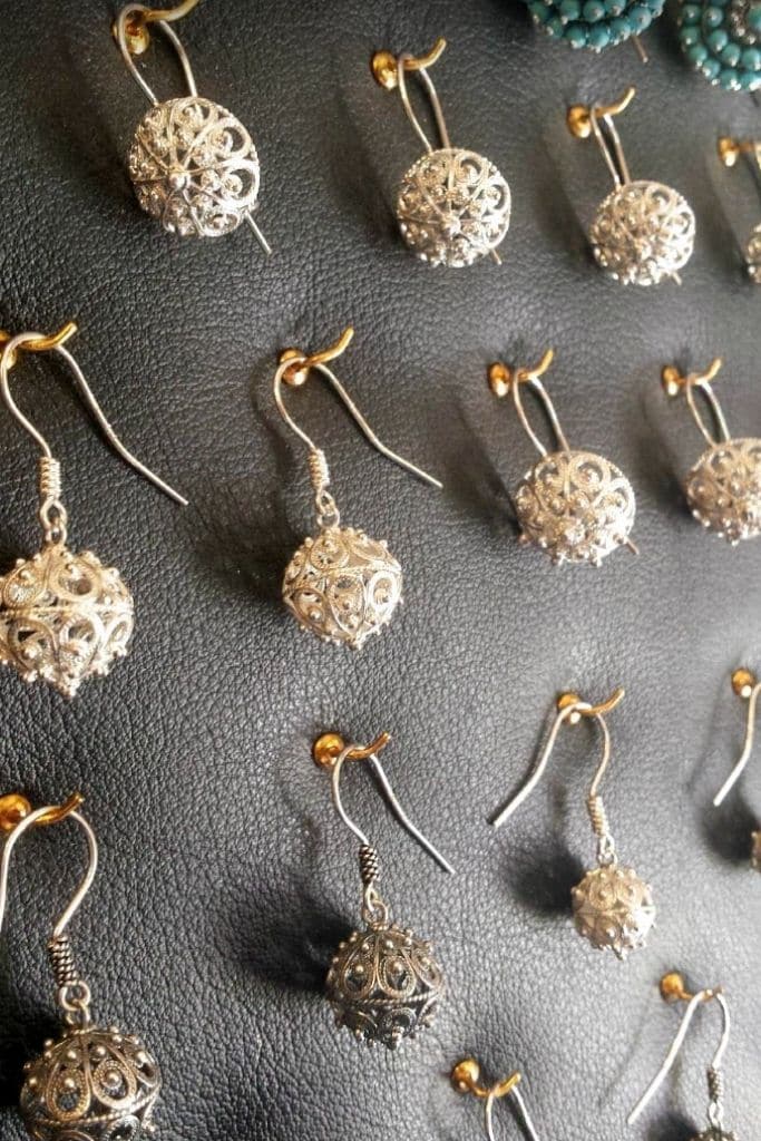 Silver Croatian Filigran earrings pined to a board.