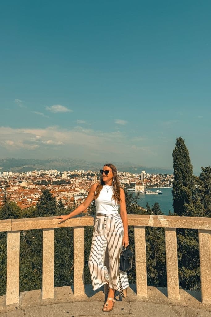 Kate leans agains a stone terrace that overlooks the old town of Split Croatia