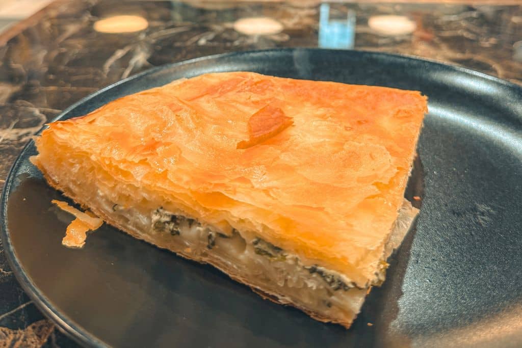 Large square serving of a Burek pastry on a plate.