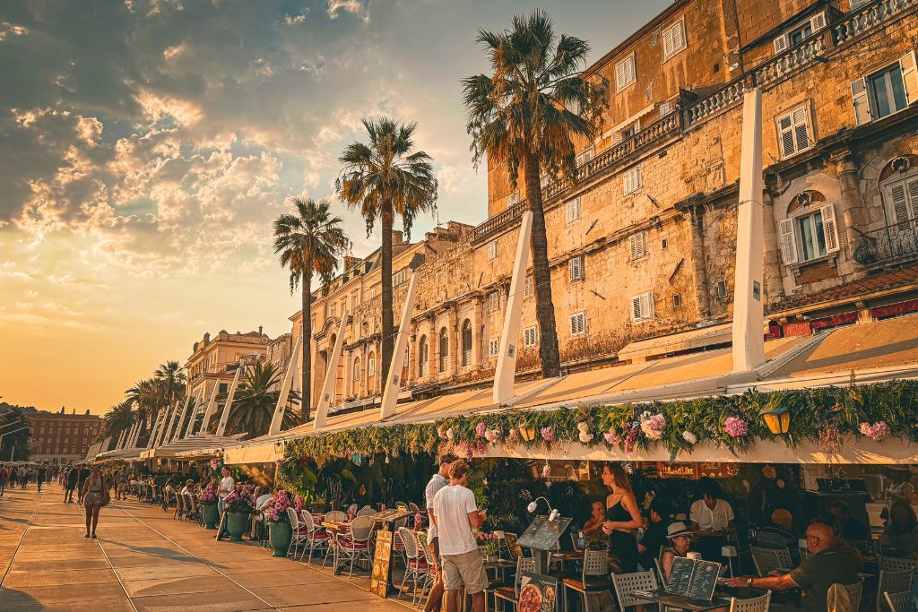 The Riva in Split Croatia, lined with restaurants and shops at sunset.