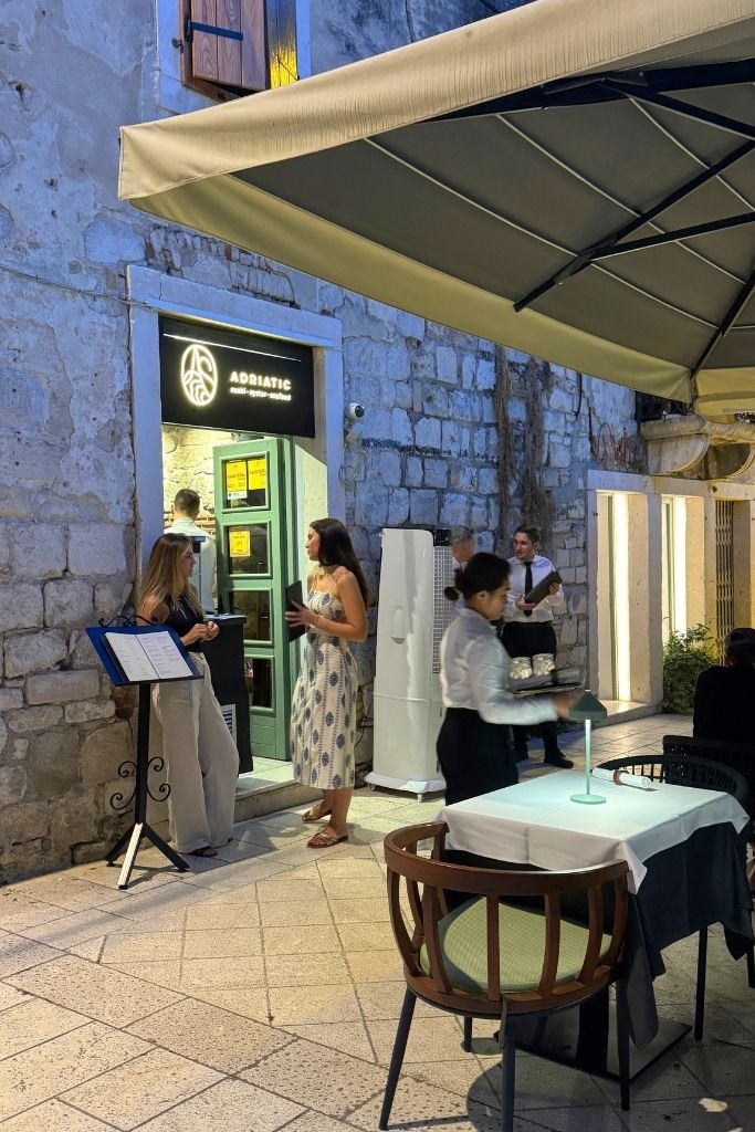 Entry to Adriatic Sushi & Oyster Bar in Split with customers waiting outside.