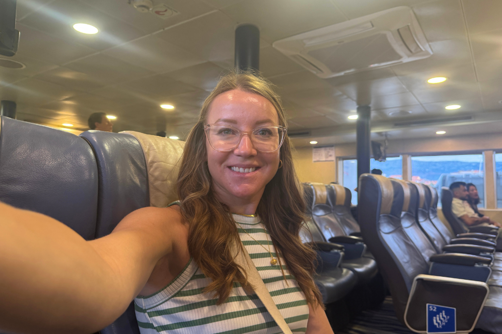Kate taking a selfie from inside a Ferry boat in her seat.