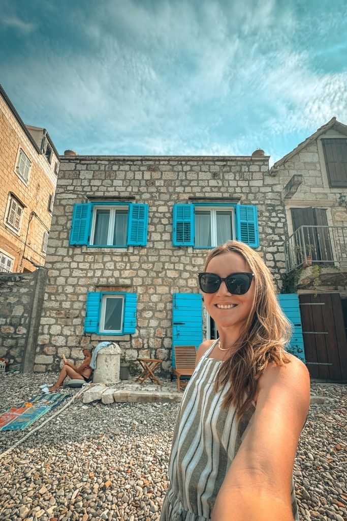 Kate taking a selfie with the famous blue shutter house on Vis.
