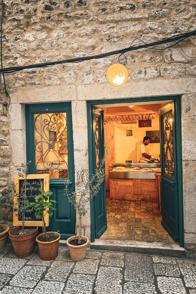 Store front with green doors and a sign outside that offers Oyster shots.