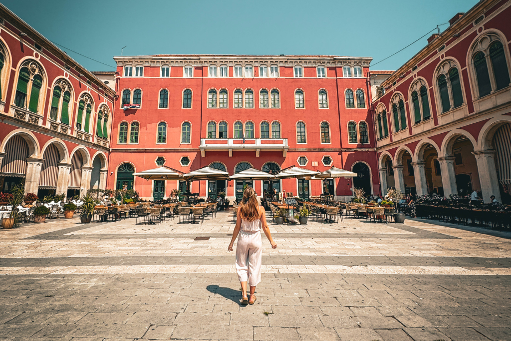 Kate walking through Republic Square in Split croatia on a sunny day. 