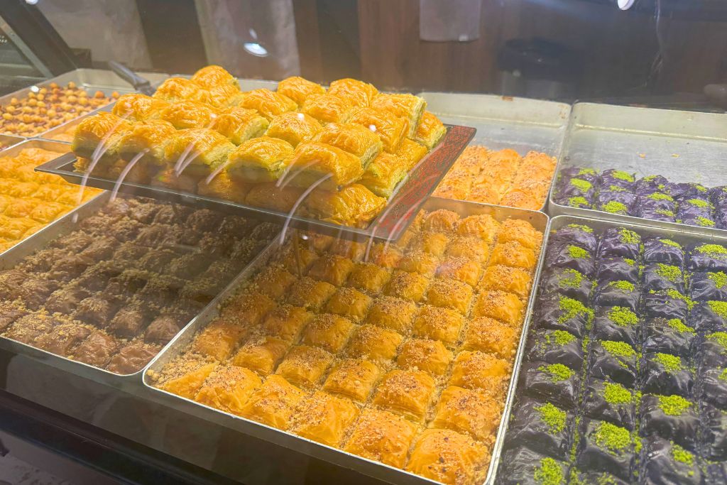 A shop counter full of trays of baklava. 