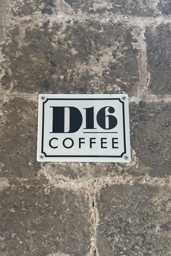 small white plaque with black lettering that says D16 Coffee