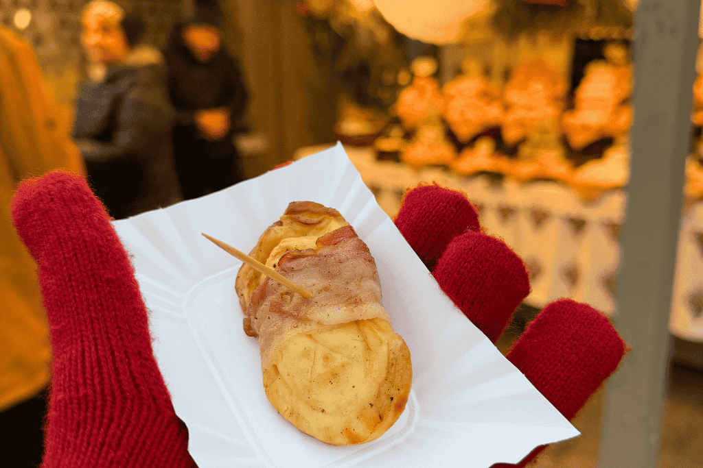 A bacon-wrapped grilled cheese snack served hot at the Krakow Christmas Market in Poland.