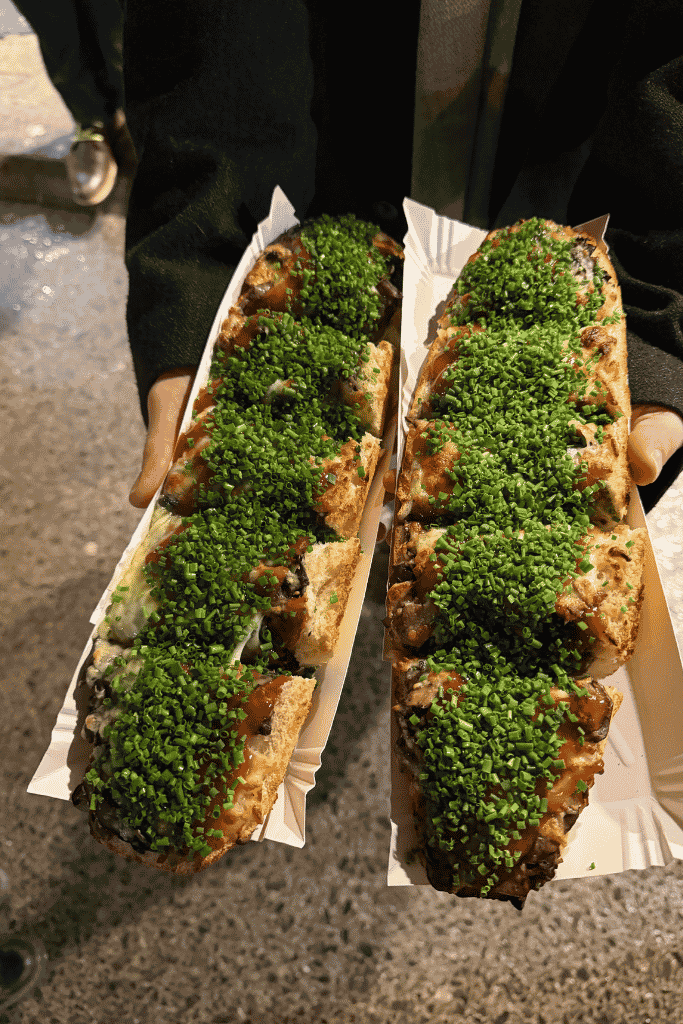 Traditional Polish zapiekanki topped with mushrooms, sauce, and fresh chives in Krakow, Poland.